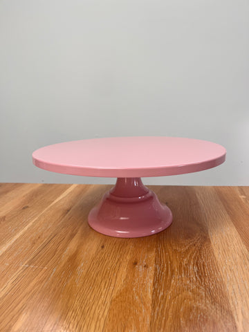 Pink stand on a wooden surface with a white background