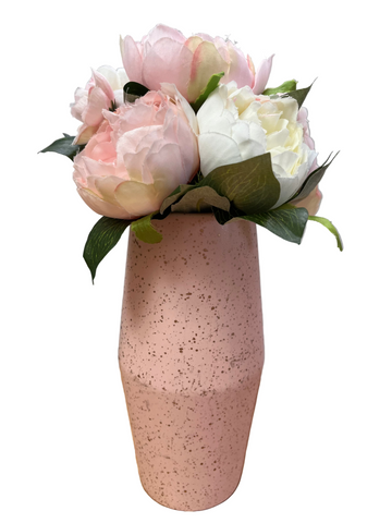 Pink speckled vase with pink and white flowers on a wooden surface