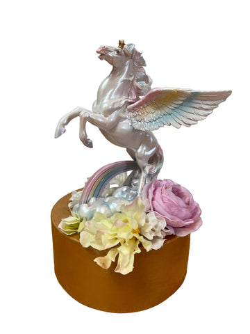 Decorative item with a unicorn and flowers on a wooden surface
