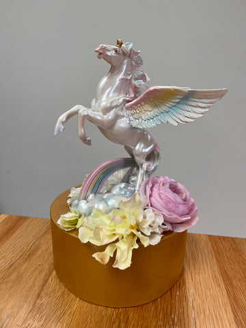 Decorative item with a unicorn and flowers on a wooden surface