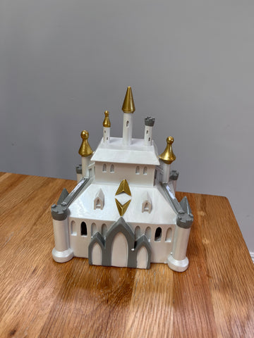 Model of a castle on a wooden surface with a gray background